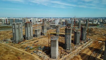Large construction site. Construction of modern multi-storey residential buildings. Construction of apartment buildings from concrete and glass. Aerial photography.