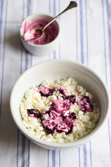 Homemade cottage cheese in a deep plate. Milk product. Granular cottage cheese with black currant jam