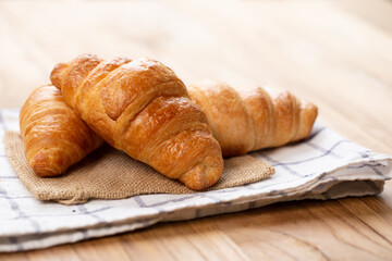 Two croissants are on plate. Croissant is a buttery, flaky, French  pastry. This bread uses the French yeast-leavened laminated dough. Crispy and yummy.