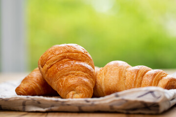 Two croissants are on plate. Croissant is a buttery, flaky, French  pastry. This bread uses the French yeast-leavened laminated dough. Crispy and yummy.