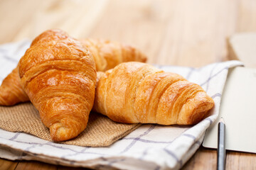 Two croissants are on plate. Croissant is a buttery, flaky, French  pastry. This bread uses the French yeast-leavened laminated dough. Crispy and yummy.