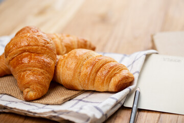 Two croissants are on plate. Croissant is a buttery, flaky, French  pastry. This bread uses the French yeast-leavened laminated dough. Crispy and yummy.