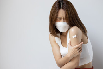 Concept image of fully vaccinated asian woman wearing face mask with side effect from vaccine shot or long covid