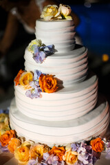 Obraz na płótnie Canvas Multilevel wedding cake decorated with colorful flower