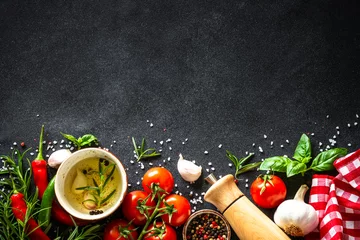 Photo sur Plexiglas Manger Fond de nourriture. Légumes frais, épices et herbes à table en pierre noire. Vue de dessus avec espace pour le design.