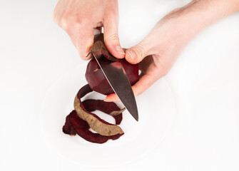 Blurred image of red beet peeling with a knife.