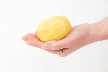 In hand peeled potatoes on a white background. Simple food.