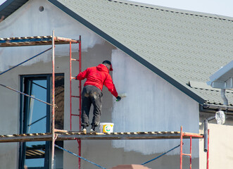 close up details of painting walls, industrial worker using roller and other tools for painting walls of new house