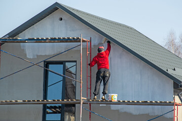 close up details of painting walls, industrial worker using roller and other tools for painting walls of new house