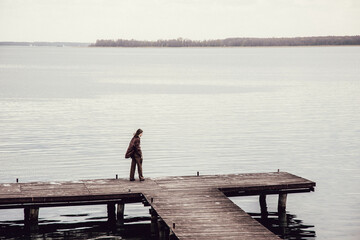 zamyślona postać - stary pomost - jezioro Śniardwy - Mazury - dziewczyna - depresja - smutek - zamyślenie - obrazy, fototapety, plakaty