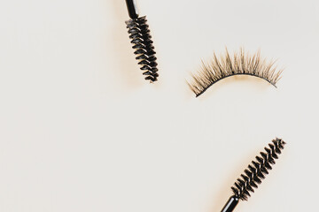 Overhead eyelashes and brushes on yellow background. Makeup of female eyes. Eyelash extension. Piece care.