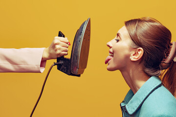 Funny image. Colorful photography of young woman sticking tongue out in front of vintage iron...