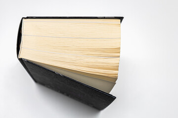 a thick volume of a paper book lies on a white table