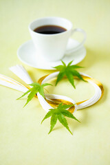 Obraz na płótnie Canvas コーヒーと水引リースと緑のモミジの葉のデザイン