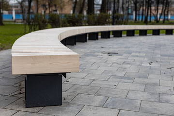 semicircular wooden bench in the city park