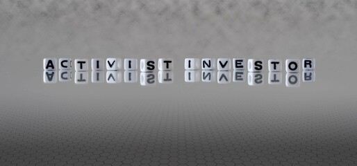 activist investor word or concept represented by black and white letter cubes on a grey horizon...