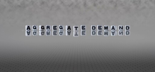 aggregate demand word or concept represented by black and white letter cubes on a grey horizon...
