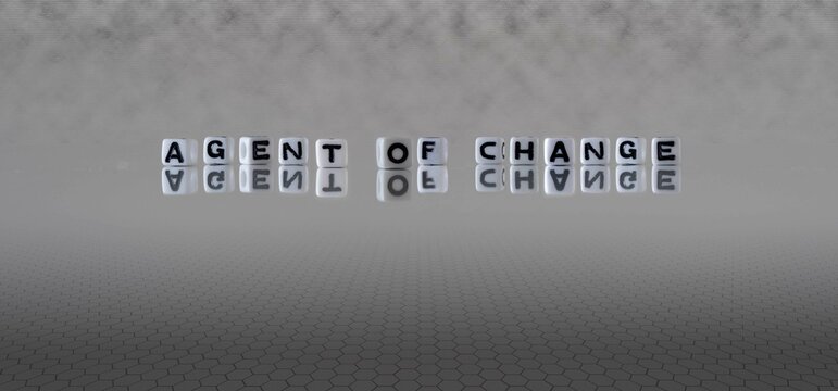 agent of change word or concept represented by black and white letter cubes on a grey horizon background stretching to infinity