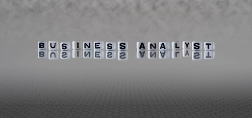 business analyst word or concept represented by black and white letter cubes on a grey horizon background stretching to infinity