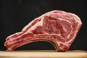 Raw beef ribs. Raw meat on wooden board. Beef steak and ingredients for preparing. Shallow depth of field