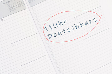 The words german course at 11 o´clock are standing in the german language in the calendar,...