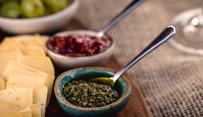 small clay bowl with pesto sauce, an italian sauce, made from basil with pine nuts, garlic, salt, grated parmesan or pecorino cheese, mixed with extra virgin olive oil with black pepper