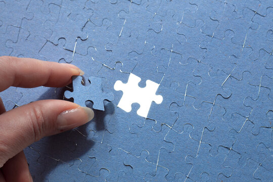 hand puts the last element of the puzzle, finding a suitable solution, completing the project