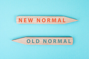 The words new and old normal are standing on wooden arrows, transformation of society after...