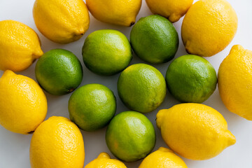 Top view of fresh limes and lemons on white background