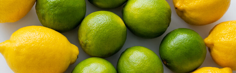 Top view of lemons and limes on white background, banner