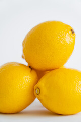 Close up view of blurred yellow lemons on white background