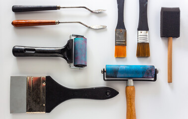 Collection of acrylics mixed media painting tools on white background in top view.
