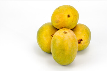 Mangoes Badami / Alphonso isolated in white background, shot using studio lighting and water drops on the subject, Composition on a wooden log with extendable white background and ample copy space.