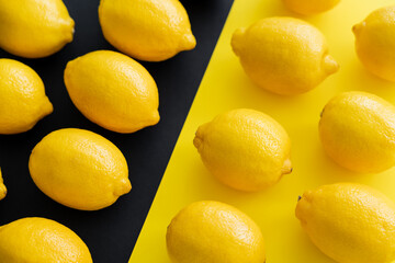 Flat lay with juicy lemons on yellow and black background