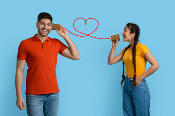 Loving Arab Woman Telling Romantic Words To Boyfriend Through Tin Can Phone