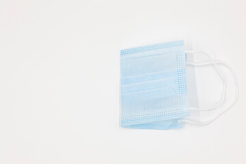 disposable blue new medical mask folded in half isolated on a white background