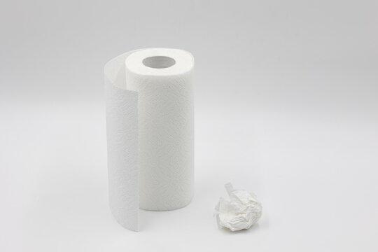 Roll Of White Paper Napkins For Kitchen And Cleaning And Crumpled Used White Napkin On A White Background