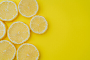 Top view of sliced lemon on yellow background with copy space