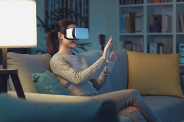 Woman relaxing on the sofa and interacting with virtual reality