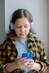 Girl listens to music with headphones. Girl listens to music with headphones and looks at the phone