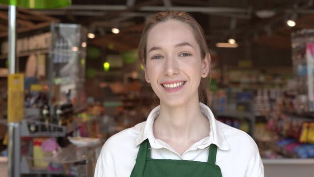 The girl supermarket cashier smiles for the camera. High quality FullHD footage