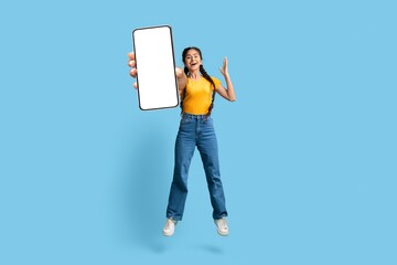 Online Offer. Overjoyed Young Arabic Woman Jumping With Big Blank Smartphone