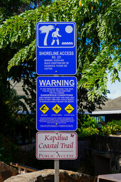 Warning sign at the entrance of the Kapalua Coastal Trail in West Maui, Hawaii - Dangerous conditions with possible high surf, strong current and slippery rocks on the oceanside walking path