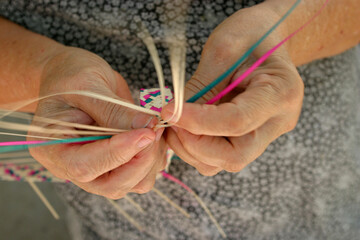 hands of a woman make a handmade craft basquets