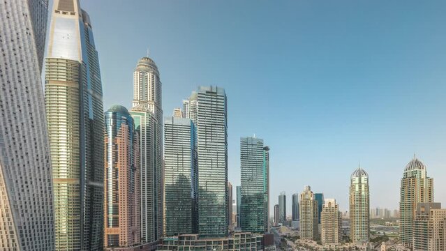 Dubai marina tallest skyscrapers and yachts in harbor aerial timelapse.