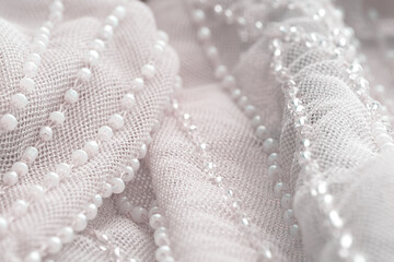 Lace skirt decoration, beadwork, close-up, selective focus. Beads thread clothing detail macro,...