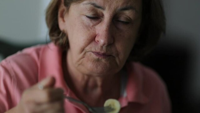 Senior woman eating banana older person eats healthy food