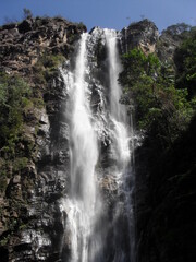 high waterfall amid very green