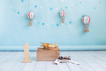 Festive decor. Wooden toy plane on a blue background with hot air balloon toy. Decor for a child's birthday