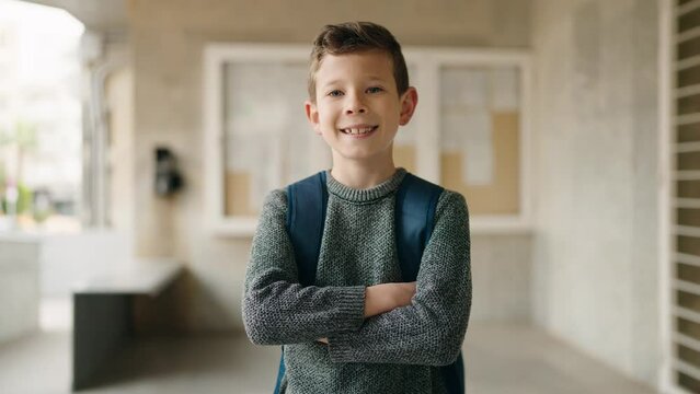 Blond child student smiling confident standing with arms crossed gesture at school